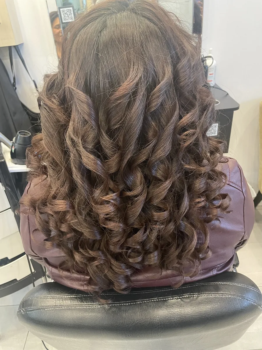 Boucles brunes serrées sur cheveux mi-longs